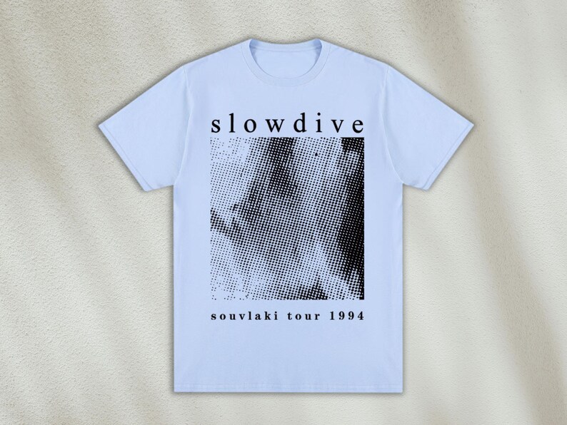 K&ouml;nnte beinhalten: Hellblaues T-Shirt mit einem schwarz-wei&szlig;en Grafikdruck eines Gesichts und dem Text "slowdive souvlaki tour 1994".
