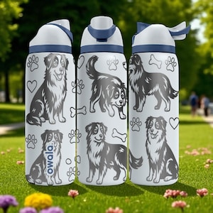 May include: Three white water bottles with blue accents and lids. Each bottle features a repeating pattern of dog illustrations, paw prints, hearts, and bones. The word "owala" is printed on one bottle.