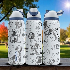 May include: Three white water bottles with blue accents and lids. Each bottle features a Dalmatian dog illustration, paw prints, bones, and other dog-themed graphics. The bottles have the brand name "owala" printed on them.