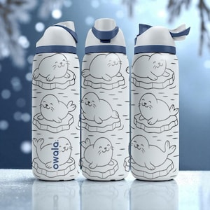 May include: Three white water bottles with a blue lid and accents. Each bottle features a repeating pattern of cartoon seals on ice floes. The word "owala" is printed on the bottom of one bottle.