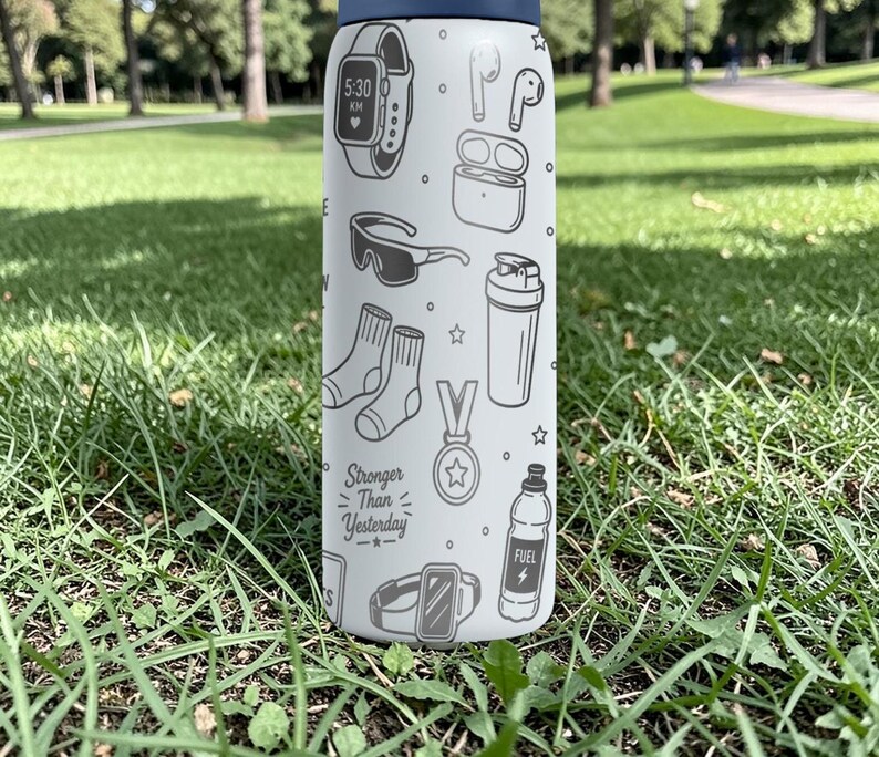 May include: A white water bottle with a navy blue lid, decorated with black and white line drawings of fitness-related items. The bottle features a watch, headphones, socks, and the text "Stronger Than Yesterday."