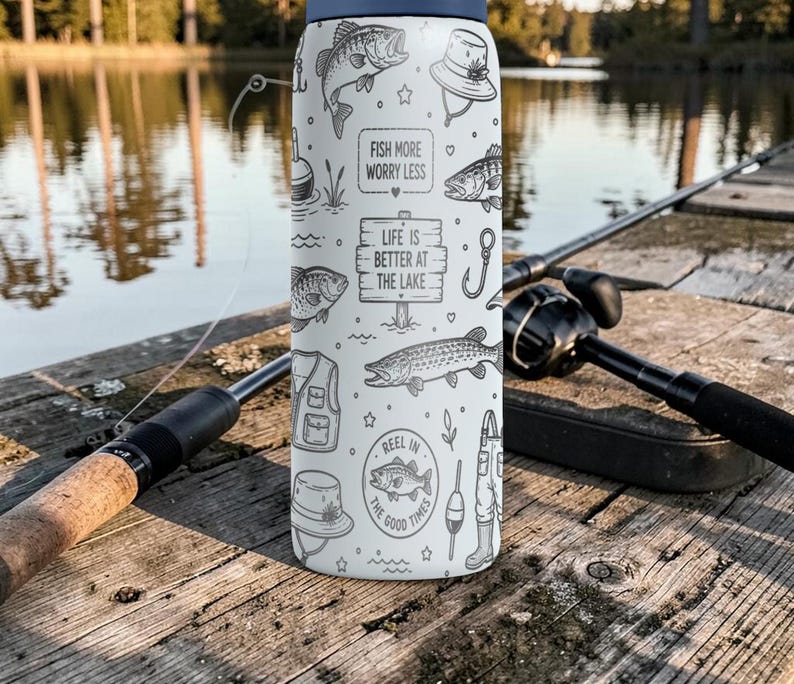 May include: A white and navy blue water bottle with fishing-themed illustrations and text. The bottle features drawings of fish, fishing gear, and the phrases "Fish More Worry Less" and "Life is Better at the Lake."