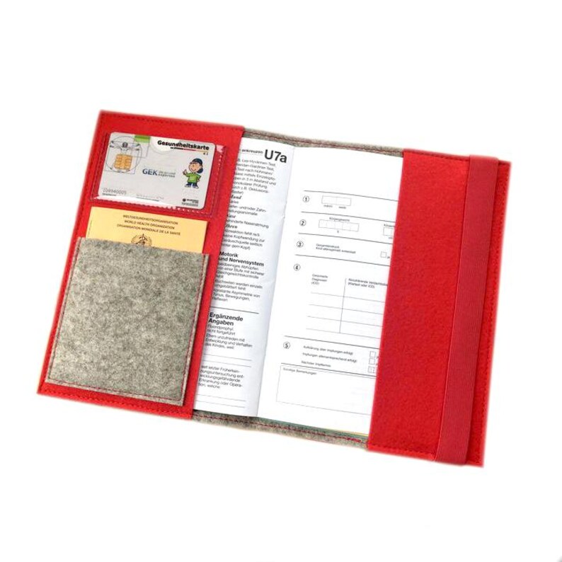 May include: Red felt folder with a gray felt pocket and a clear plastic pocket for a health insurance card. The folder has a label that says "U7a" and includes a section for "Ersprinzende Angaben".