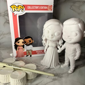 May include: A white, unpainted Funko Pop! figure set of a couple holding hands, with a matching box labeled "Collector's Edition 12." The set includes paint pots and a brush. The box art shows a couple in formal attire.