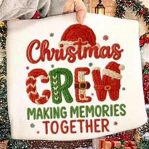Op de afbeelding: Een wit kerstbord met de woorden "Christmas CREW" in rood en groen, en "MAKING MEMORIES TOGETHER" in groen. De letters zijn ontworpen om eruit te zien als gebreide truien en een kerstmuts.