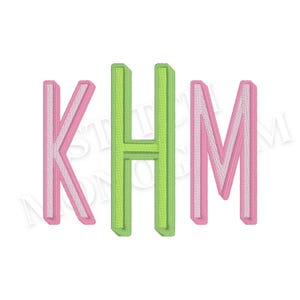 May include: Embroidered monogram with the letters KHM. The letters are in a 3D style with a pink and white color scheme for the K and M, and a green and white color scheme for the H. The background is white.