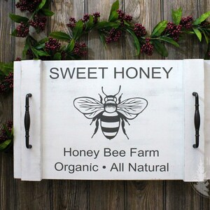 May include: White wooden serving tray with black handles. The tray has a black and white bee graphic and the text "SWEET HONEY Honey Bee Farm Organic • All Natural".