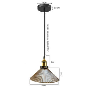 May include: Black pendant light with a brown glass shade. The shade has a ribbed design and measures 11 inches in diameter. The light fixture has a 10-inch diameter ceiling plate and an adjustable wire length of up to 37.4 inches.