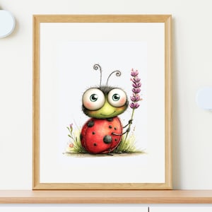 Op de afbeelding: Een ingelijste prent van een cartoon lieveheersbeestje met een rode schaal en zwarte stippen, met een takje paarse lavendel. Het lieveheersbeestje heeft grote ogen en een groene kop. Het kunstwerk is ingelijst in een houten frame.