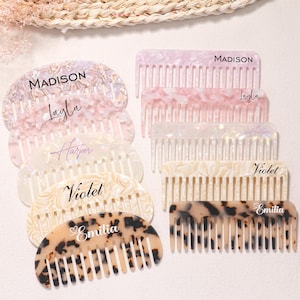 Puede incluir: Una colección de peines personalizados en varios colores, incluyendo rosa, blanco y carey. Cada peine presenta un nombre en escritura elegante: Madison, Layla, Harper, Violet y Emilia. Los peines están dispuestos sobre un fondo claro.