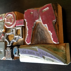 May include: A collection of vintage wood printing blocks with various designs, including a red key, a state of Texas outline, and the text "B.T. OWENS WIRE INC."