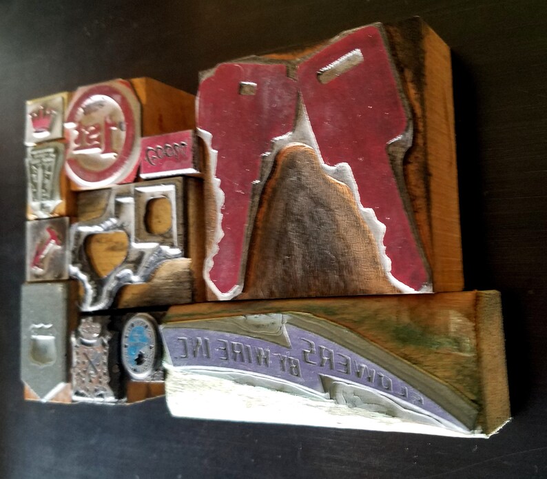 May include: A collection of vintage wood printing blocks with various designs, including a red key, a state of Texas outline, and the text "B.T. OWENS WIRE INC."