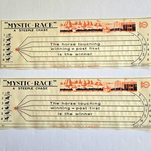 May include: Two vintage "Mystic-Race" steeple chase game cards. The cards are cream-colored with black text and orange illustrations. Each card features a diagram of a race track, horse illustrations, and the text "The horse touching winning - post first is the winner."