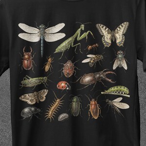 Könnte beinhalten: Schwarzes T-Shirt mit einer detaillierten Illustration verschiedener Insekten, darunter eine Libelle, ein Schmetterling und ein Käfer. Das Shirt hat oben den Text "JoJoTeez" und unten "BUY 3 GET FREE SHIPPING". Das Shirt hat auch den Text "BULK SALE" mit einem Rabattcode.
