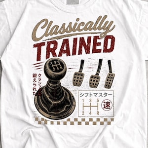 Może przedstawiać: Biały t-shirt z grafiką ręcznej dźwigni zmiany biegów i trzema pedałami. Napis głosi Classically Trained, obok znajdują się japońskie znaki i schemat zmiany biegów. Projekt zawiera szachownicę w dolnej części nadruku.
