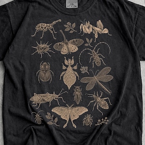 Op de afbeelding: Een zwart t-shirt met korte mouwen en een gedetailleerde beige grafische print van diverse insecten, waaronder kevers, motten en libellen, die in een verspreid patroon over het borstgedeelte zijn afgebeeld.