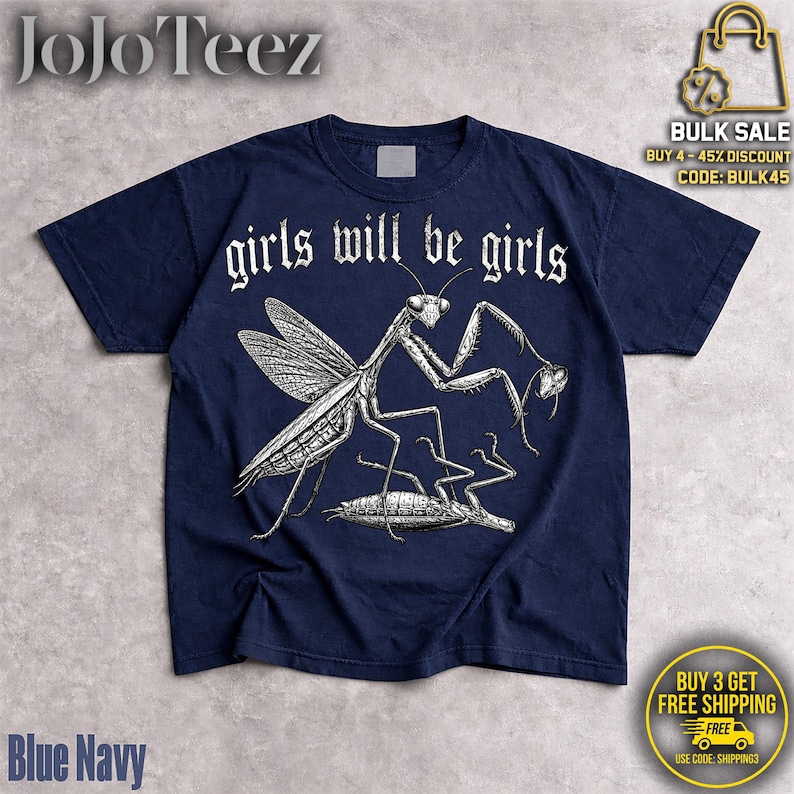 May include: A navy blue short-sleeve t-shirt featuring a white graphic illustration of a praying mantis standing over another insect. The text "girls will be girls" is printed in a white gothic-style font above the insect illustration.