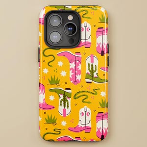 May include: Yellow phone case with a repeating pattern of pink and white cowboy boots, green cacti, and snakes. The case also features small white stars and green grass accents. The brand name "LILOU FLORAL DESIGNS" is printed at the bottom.