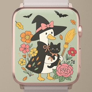 Könnte beinhalten: Eine roségoldene Smartwatch zeigt ein skurriles Halloween-Design. Eine Ente mit Hexenhut und Umhang hält eine schwarze Katze und einen Besen. Der Hintergrund zeigt Blumen, Fledermäuse und Herbstblätter.
