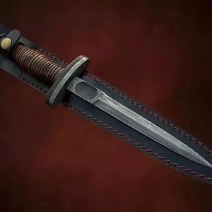 Peut inclure: Un fourreau en cuir noir avec des surpiqûres rouges contient un poignard argenté à manche torsadé. Le poignard a une pointe acérée et une lame à double tranchant.