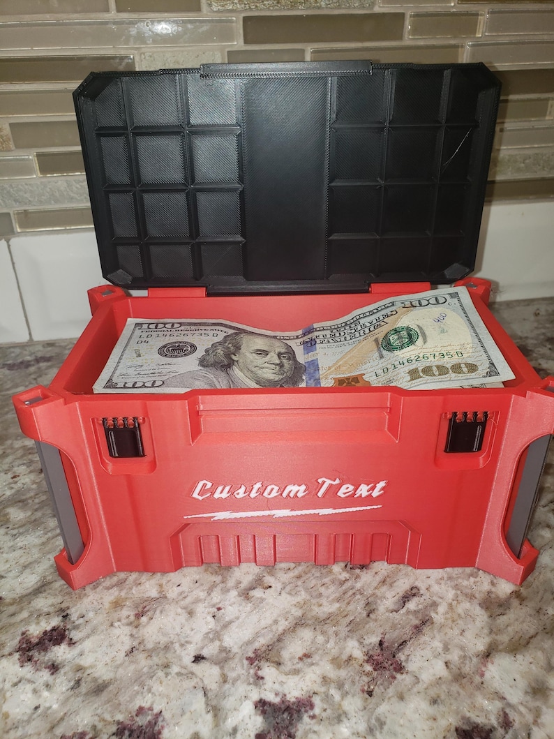 May include: Red storage box with a black lid, open to reveal several one hundred dollar bills. The box has the words "Custom Text" printed on the front.