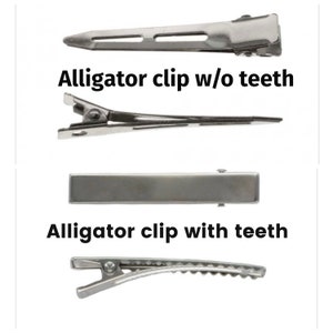 May include: Two silver alligator clips, one with teeth and one without. The clip without teeth is labeled "Alligator clip w/o teeth" and the clip with teeth is labeled "Alligator clip with teeth".