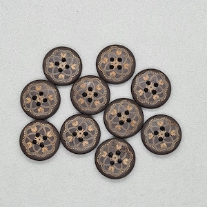 May include: Ten dark brown wooden buttons with a gold floral design. Each button features four holes and a detailed, symmetrical pattern. The round buttons are approximately 2.5 cm in diameter, suitable for various sewing projects.