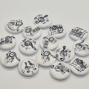 May include: A selection of white, circular buttons adorned with black musical notations and symbols. Each button showcases a unique design, including treble clefs, piano keys, and musical scores. These decorative buttons are perfect for sewing and craft projects.