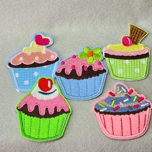 May include: Five colourful embroidered cupcake patches with various designs, including sprinkles, cherries and flowers. The patches are perfect for adding a touch of whimsy to clothing, bags or other crafts.