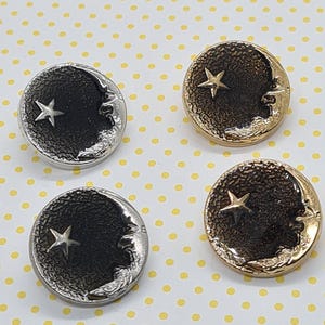 May include: Four circular buttons featuring celestial designs. Two are silver-toned with a crescent moon and star, and two are gold-toned. The buttons are set against a yellow background with white polka dots.