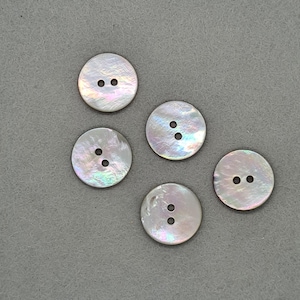 May include: Five round, iridescent mother-of-pearl buttons, each with two holes. The buttons have a pearlescent sheen with hints of blue, green, and pink. They are arranged on a grey surface.