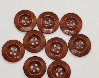 May include: Eight round, dark brown wooden buttons are displayed. Each button features four sewing holes and a raised central area. The buttons are arranged on a white background.