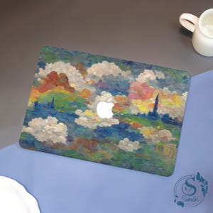 May include: A laptop with a colorful, impressionistic design featuring clouds, a landscape, and a white Apple logo. The artwork includes shades of blue, green, yellow, orange, and white. The laptop is on a blue surface.