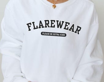 May include: White sweatshirt with the text "FLAREWEAR" in bold black letters, with "PLEASE BE EXTRA KIND" underneath. The sweatshirt is a long-sleeved crew neck. The words "HER ROOTED WELLNESS" are at the bottom of the image.