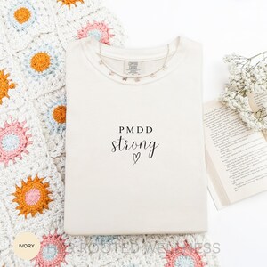 PMDD Strong Shirt | Comfort Colors Premenstrual Dysphoric Disorder Awareness T-Shirt | Support Gift Idea for PMDD Warrior, Advocacy Text Tee