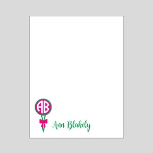 May include: A white stationery card with a green and pink monogrammed golf tee design. The monogram is "AB" and the name "Ann Blakely" is written in green cursive.