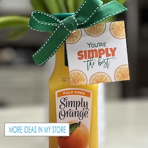 May include: A gift basket with a bottle of Simply Orange pulp-free juice and a gift tag that says "You're Simply the Best". The gift tag has a white background with orange slices and green leaves.