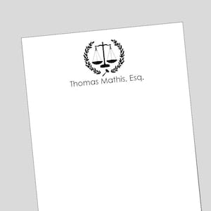May include: Black and white image of a scale of justice with a gavel, surrounded by a laurel wreath. The text "Thomas Mathis, Esq." is below the image.