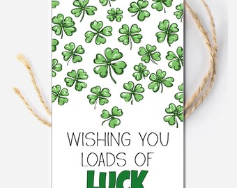 May include: A white gift tag with a green shamrock pattern and the text "Wishing you loads of luck".