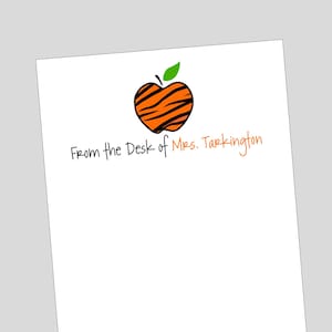 May include: White card with an orange and black striped apple with a green stem and leaf. The text "From the Desk of Mrs. Tarkington" is written in black cursive.