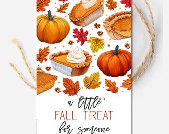 May include: A white gift tag with a fall theme. The tag features illustrations of pumpkins, pumpkin pie, and autumn leaves. Text on the tag reads "a little FALL TREAT for someone SO SWEET!" A natural twine string is attached.