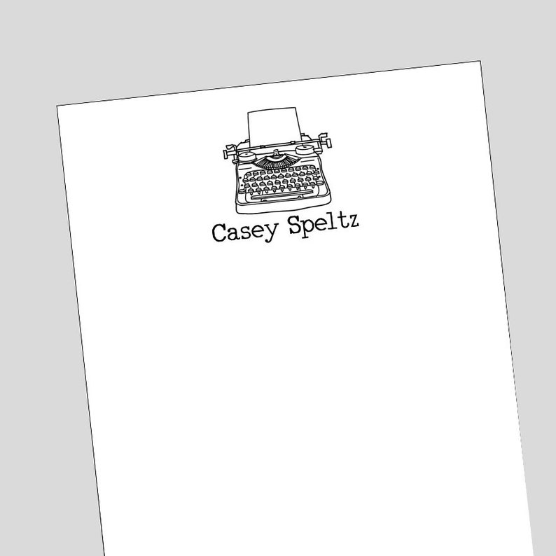 Pu&ograve; includere: Un'illustrazione in bianco e nero di una macchina da scrivere vintage con il nome "Casey Speltz" stampato sotto.