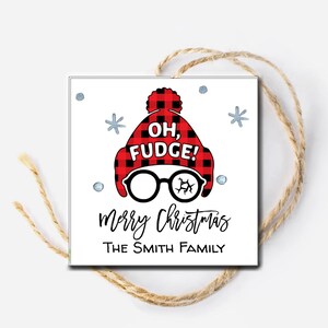 May include: A white Christmas gift tag with a red and black plaid hat with the text "Oh, Fudge!" and glasses. The tag also has the text "Merry Christmas The Smith Family".