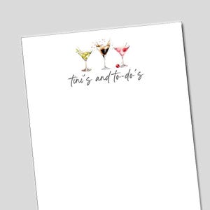 May include: A white notepad with three watercolor martini glasses. The martinis are green, brown, and pink, each with different garnishes. The text "tini's and to-do's" is written in cursive below the glasses.