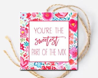 May include: A white square gift tag with a pink, red, and blue floral pattern. The tag has the text "You're the sweetest part of the mix" in pink lettering.