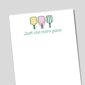 May include: Three colorful paddleball rackets with a pink bow in the center. The text "Just one more game" is written below the rackets.