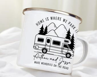 May include: White enamel camping mug with a silver rim. The mug features a black illustration of a camper van, mountains, and trees. Text on the mug reads "HOME IS WHERE WE PARK IT" and "Arthur and Jesse MAKE MEMORIES ON THE ROAD."