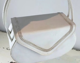 Könnte beinhalten: Eine weiße Ledertasche mit einem einzigen Henkel oben. Die Tasche hat einen Klappenverschluss und dekorative Nähte an den Rändern.