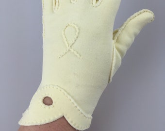 May include: A pair of off-white gloves with a decorative stitch detail. The gloves have a scalloped cuff and a small hole on the cuff.