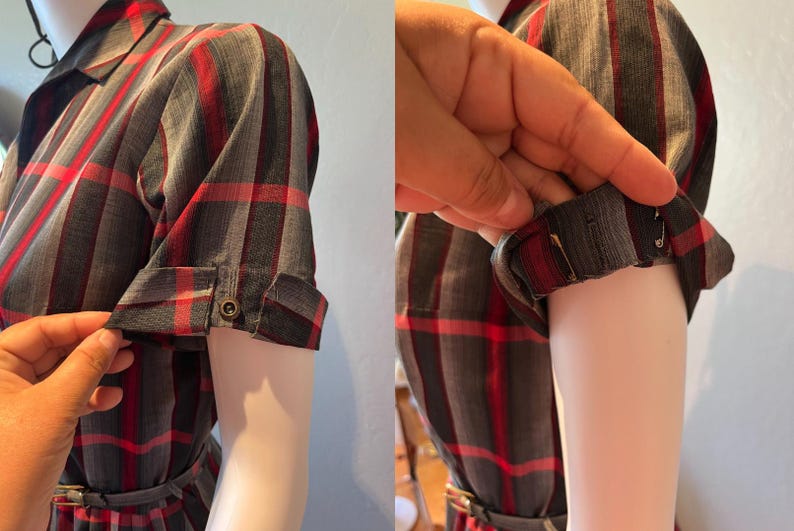Peut inclure: Une robe &agrave; carreaux grise, rouge et noire avec des manches courtes. Les manches sont retrouss&eacute;es et boutonn&eacute;es. La robe est sur un mannequin.
